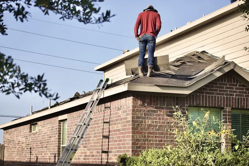Professional roofer working on a residential roof in Russell